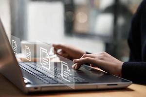 mujer de negocios escribiendo en un teclado de computadora revisando documentos concepto de gestión de documentos con iconos en la pantalla virtual erp. documentos, datos, iconos, verificación. foto