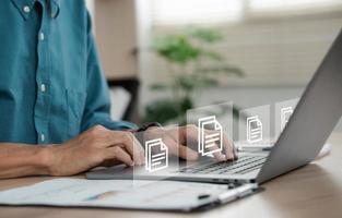 businessman sitting on a computer monitor document management concept with icons on virtual ERP screens. photo