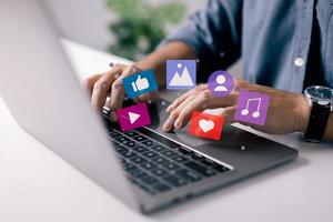 concepto de administrador de contenido. el hombre trabaja en la computadora portátil, publica según el plan video, audio e imágenes en las redes sociales. foto