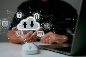 A man uses a laptop with a cloud computing diagram shown on hand. Cloud computing networking and internet service principles for data storage. photo