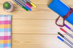 Magic colored pens, cloth bag, cactus on the wooden table. photo