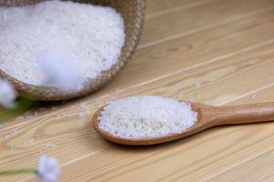 Rice in a wooden ladle background  is a container basket weave on wooden table. photo