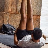 Inspired Indian young man doing yoga asanas in Lodhi Garden Park, New Delhi, India. Young citizen exercising outside and standing in yoga side angle pose. Fitness outdoors and life balance concept photo