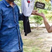 Indian couple posing for maternity baby shoot. The couple is posing in a lawn with green grass and the woman is falunting her baby bump in Lodhi Garden in New Delhi, India photo