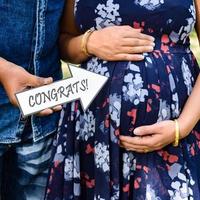 pareja india posando para una sesión de fotos de maternidad. la pareja está posando en un césped con hierba verde y la mujer está faluntando su panza en el jardín lodhi en nueva delhi, india