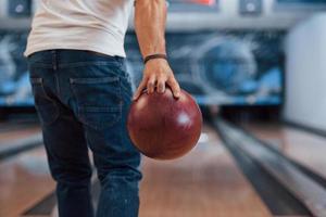 esto va a ser la huelga. vista de partículas traseras del hombre con ropa informal jugando a los bolos en el club foto