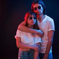 Pure love. Couple standing in dark room with red and blue neon lighting photo