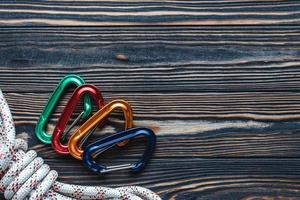 Bright and beautiful. Isolated photo of climbing equipment. Part of carabiner lying on the wooden table