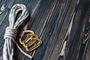 Just from production. Isolated photo of climbing equipment. Part of carabiner lying on the wooden table