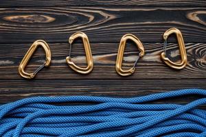 For mountaineering. Isolated photo of climbing equipment. Part of carabiner lying on the wooden table