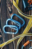 Looking nice and new. Isolated photo of climbing equipment. Parts of carabiners lying on the wooden table