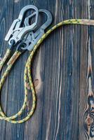 Climbing equipment. Isolated photo. Part of carabiner lying on the wooden table photo