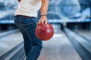 Conception of bowling. Rear particle view of man in casual clothes in the club photo