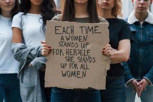 Concentration at poster. Group of feminist women have protest for their rights outdoors photo