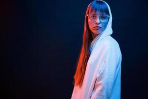 At the nightclub. Studio shot in dark studio with neon light. Portrait of young girl photo