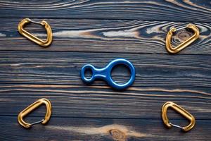 Conception of art and creativity. Isolated photo of climbing equipment. Parts of carabiners lying on the wooden table