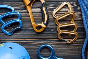 Little but strong. Isolated photo of climbing equipment. Parts of carabiners lying on the wooden table