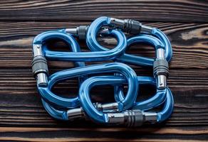 Lying on each other. Isolated photo of climbing equipment. Parts of carabiners on the wooden table