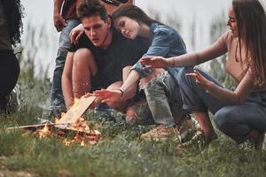 Cute hugs. Group of people have picnic on the beach. Friends have fun at weekend time photo