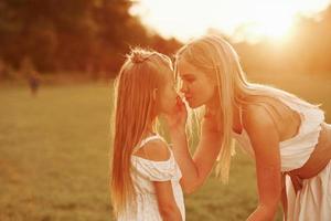 Let me take away that thing. Mother and daughter enjoying weekend together by walking outdoors in the field. Beautiful nature photo