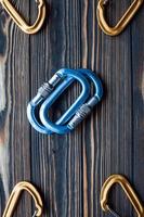 Shiny new tools. Isolated photo of climbing equipment. Parts of carabiners lying on the wooden table