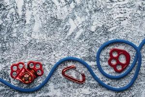 Gear of technician. Isolated photo of climbing equipment. Part of carabiner lying on the white and grey colored table