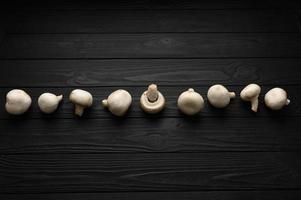 Fresh white mushrooms champignon on wooden background. photo