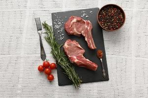 Raw cowboy steak and spices on a white background. photo