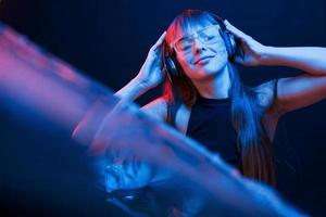 Cyberpunk style. Studio shot in dark studio with neon light. Portrait of young girl photo