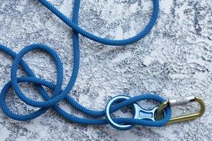 viajar y divertirse en las montañas, concepto. foto aislada del equipo de escalada. parte del mosquetón sobre la superficie de color blanco y gris