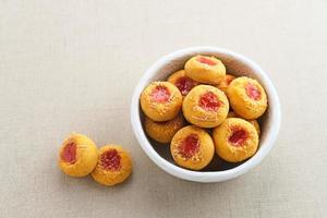 Thumb print cookies filled with strawberry jam and grated cheese.  Familiar during the month of Ramadan and Eid Fitri. photo