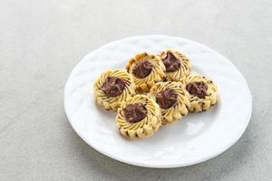 galletas de mantequilla de nutella, galletas populares para celebraciones de eid en indonesia. servido en plato blanco sobre fondo gris foto