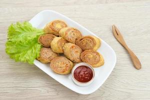 Chicken Egg rolls, made from mixtured minced chicken with tapioca, carrots, scallions and eggs then rolled, steamed and fried photo