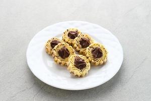 galletas de mantequilla de nutella, galletas populares para celebraciones de eid en indonesia. servido en plato blanco sobre fondo gris foto