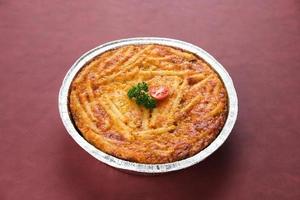 Baked Macaroni Schotel in an aluminium foil cup. Selective focus. photo