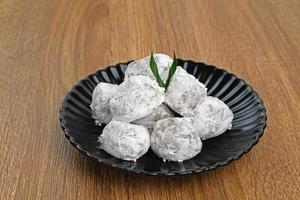 Mochi dessert with peanut paste filling served on plate on wooden board. Selected focus. photo