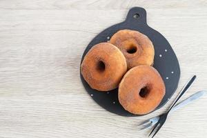 Donat Kentang, Potatoes Donut, donuts with added potato ingredients. Dusted with powdered chocolate and served on a small plate. photo