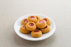 Thumb print cookies filled with strawberry jam and grated cheese.  Familiar during the month of Ramadan and Eid Fitri. photo