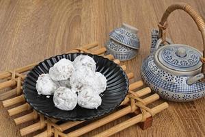 Mochi dessert with peanut paste filling served on plate on wooden board. Selected focus. photo