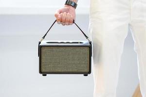 Asian man holding a luxury loudspeaker with his fist on white background. photo