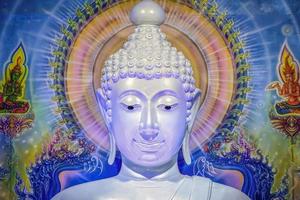 Great white Buddha statue with blue background wall. photo