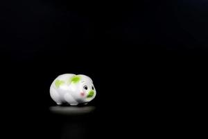 Isolated sad piggy bank on the black background with copy space. photo