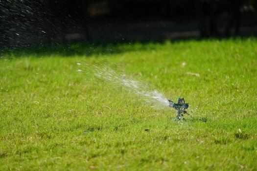 Sprinkler grass working system, working on the field in the garden. photo