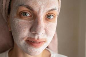 girl in a cosmetic mask on her face. woman, cream on her face. Attractive girl with moisturizing facial mask photo