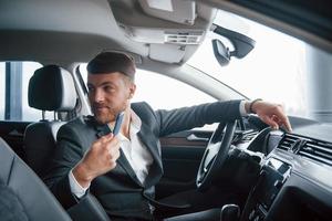 Passenger on back seat. Modern businessman trying his new car in the automobile salon photo