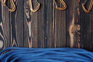 Different angle of view. Isolated photo of climbing equipment. Part of carabiner lying on the wooden table