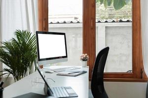 escritorio de madera con computadora con pantalla en blanco y documentos, libros, interior moderno de gabinete acogedor, mesa para hombre de negocios o estudiante en casa, espacio de trabajo cómodo, foto