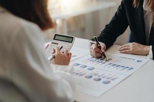 Close up Businessman and partner using calculator and laptop for calaulating finance, tax, accounting, statistics and analytic research concept photo