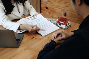 Real estate agent or bank officer describes the loan interest to the customer with home purchase contracts or on office loans and interest rates photo