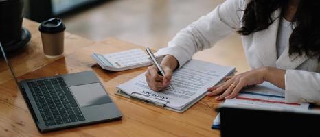 los vendedores están dejando que las clientas firmen el contrato de venta, la mujer asiática haciendo negocios en la oficina, el concepto de negocio y la firma del contrato. foto